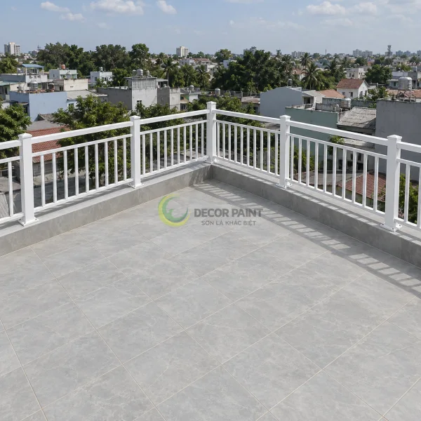 Lan can kim loại phủ sơn trắng trên sân thượng, bố trí theo hai cạnh vuông góc.