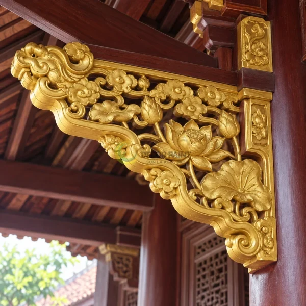 Chi tiết gỗ chạm khắc tại góc mái được phủ màu vàng ánh kim, giữ rõ đường nét trang trí.
