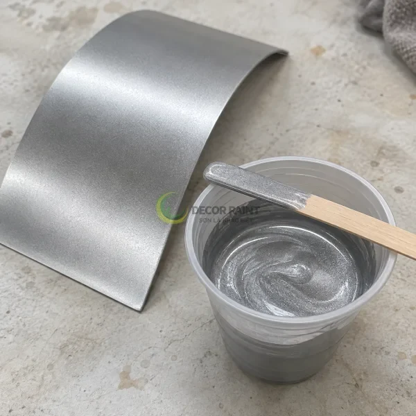 Cốc sơn màu bạc ánh kim, que khuấy và tấm mẫu cong đã phủ màu bạc