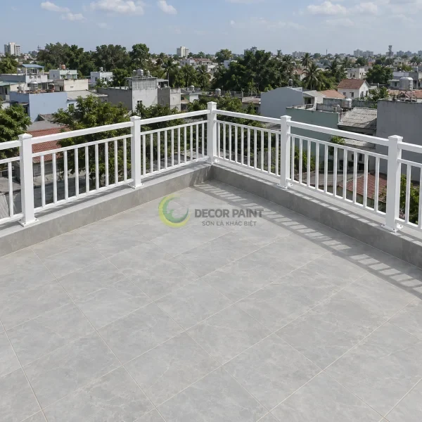 Lan can kim loại phủ sơn trắng trên sân thượng, bố trí theo hai cạnh vuông góc.